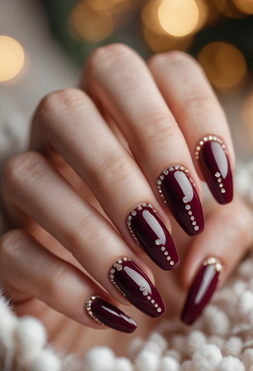 Close-up of hands with glossy burgundy nails decorated with small sparkling rhinestones.