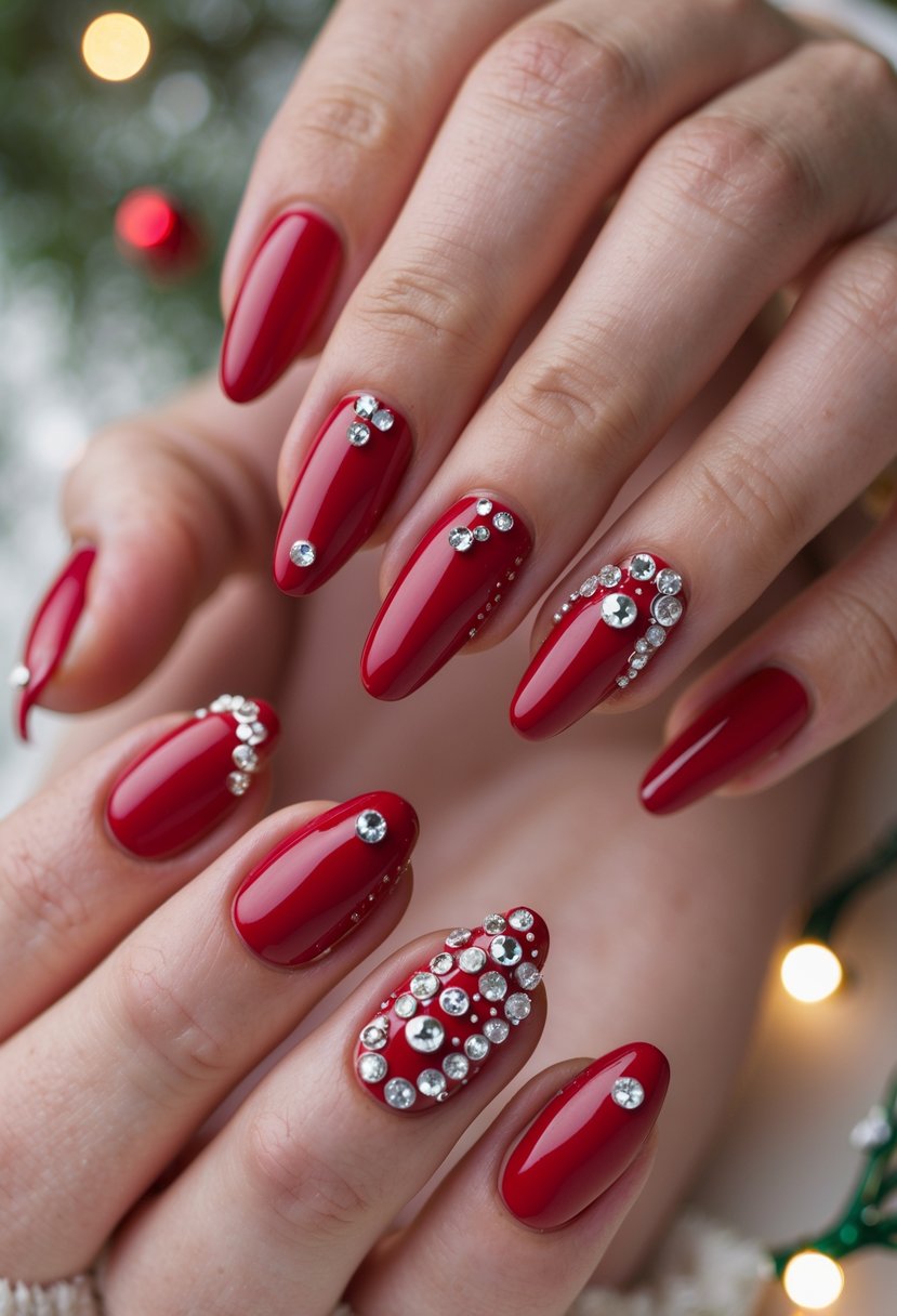 Close-up of hands with cherry red shiny nails decorated with rhinestones, posed against a soft festive background.