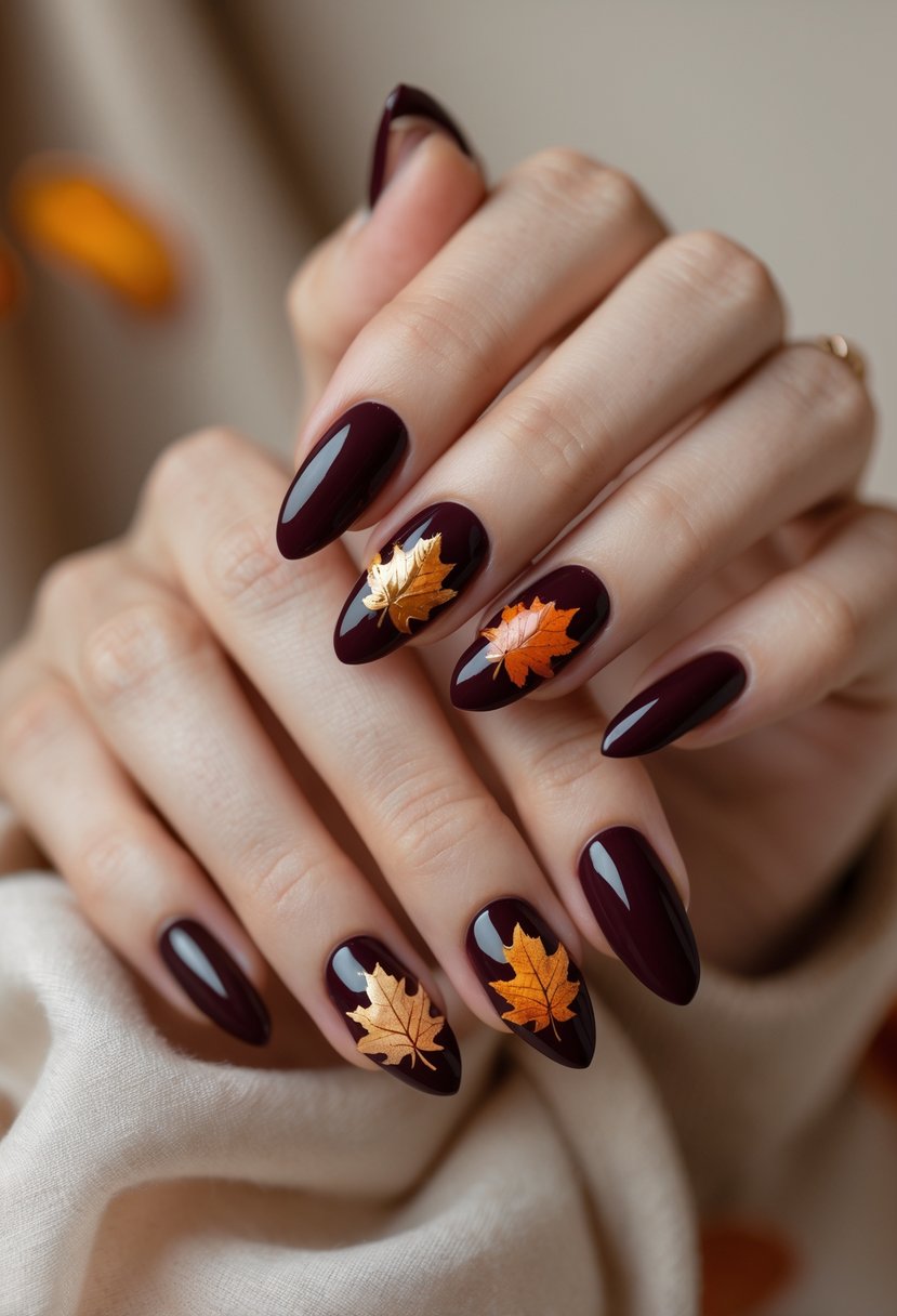 Close-up of hands with dark burgundy nails decorated with autumn leaf designs.