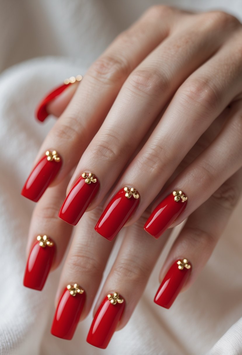 Close-up of hands with square-shaped red nails decorated with small gold dots.