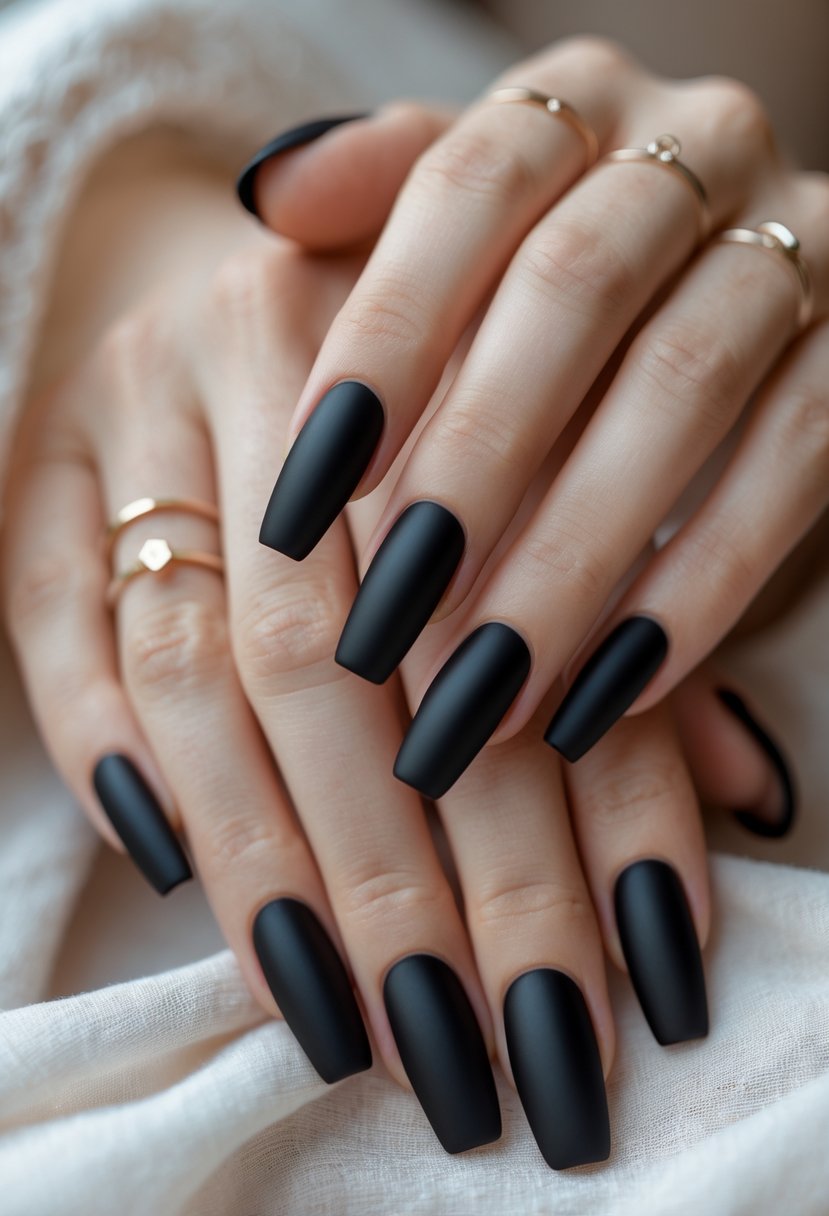 Close-up of two hands with sixteen black nails featuring matte black French tips.