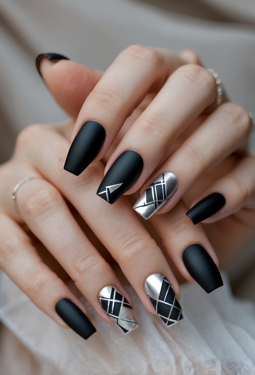 Close-up of hands with matte black nails decorated with silver geometric patterns.