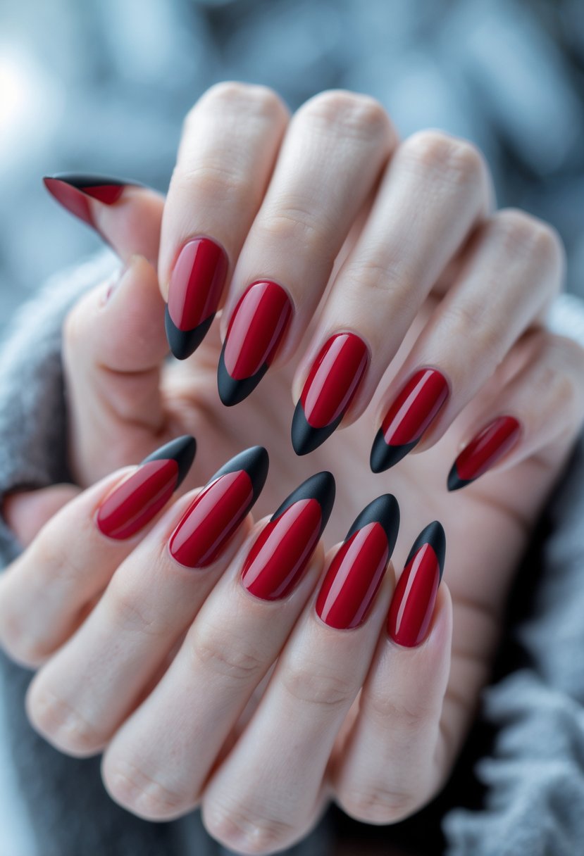 Close-up of hands with ruby red nails featuring black matte tips against a soft winter-colored background.