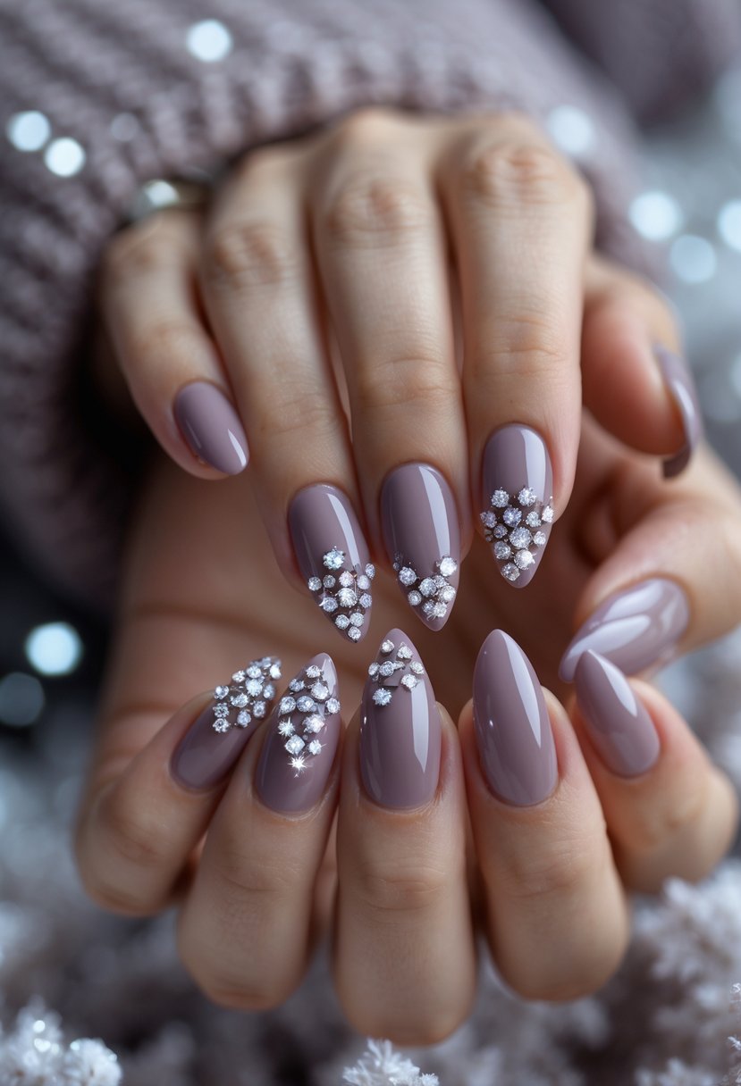 Close-up of a hand with mauve-colored nails decorated with small crystal clusters.