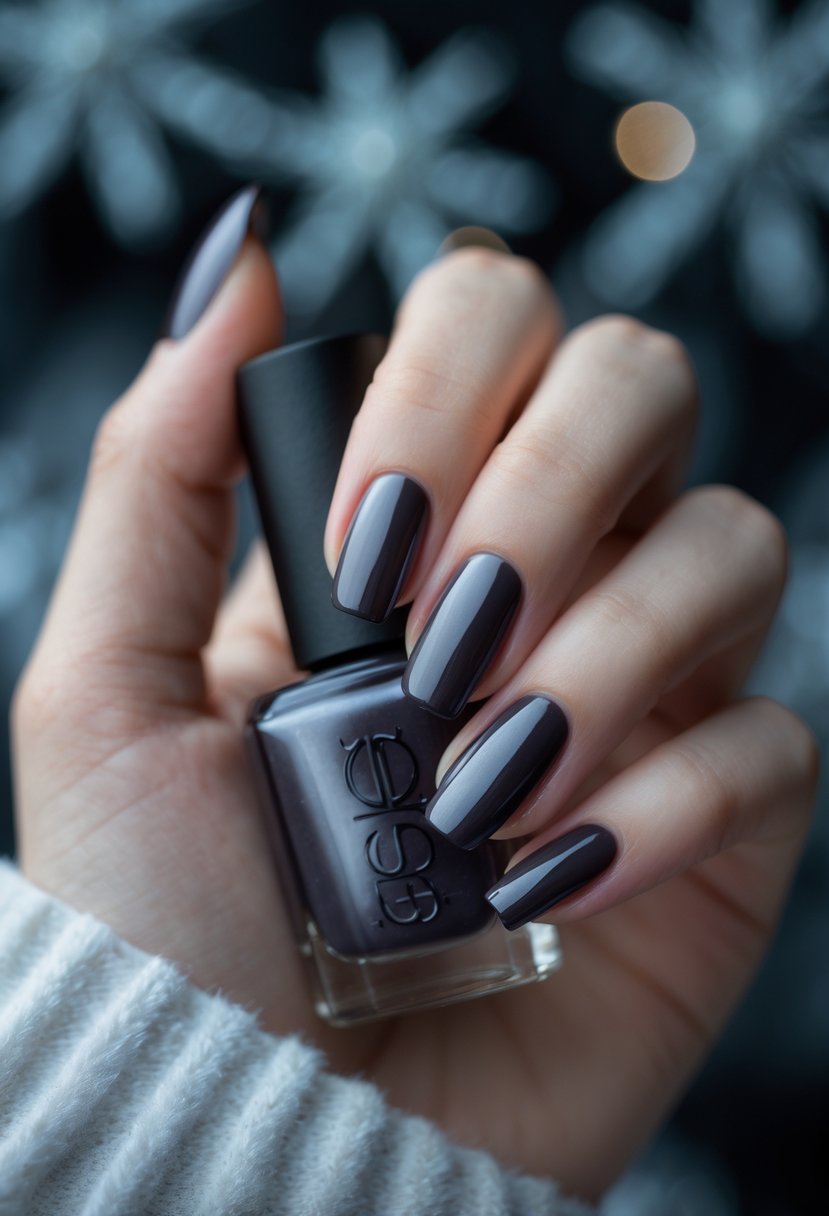 Close-up of a hand with glossy dark smoky quartz colored nails against a softly blurred cool-toned background.