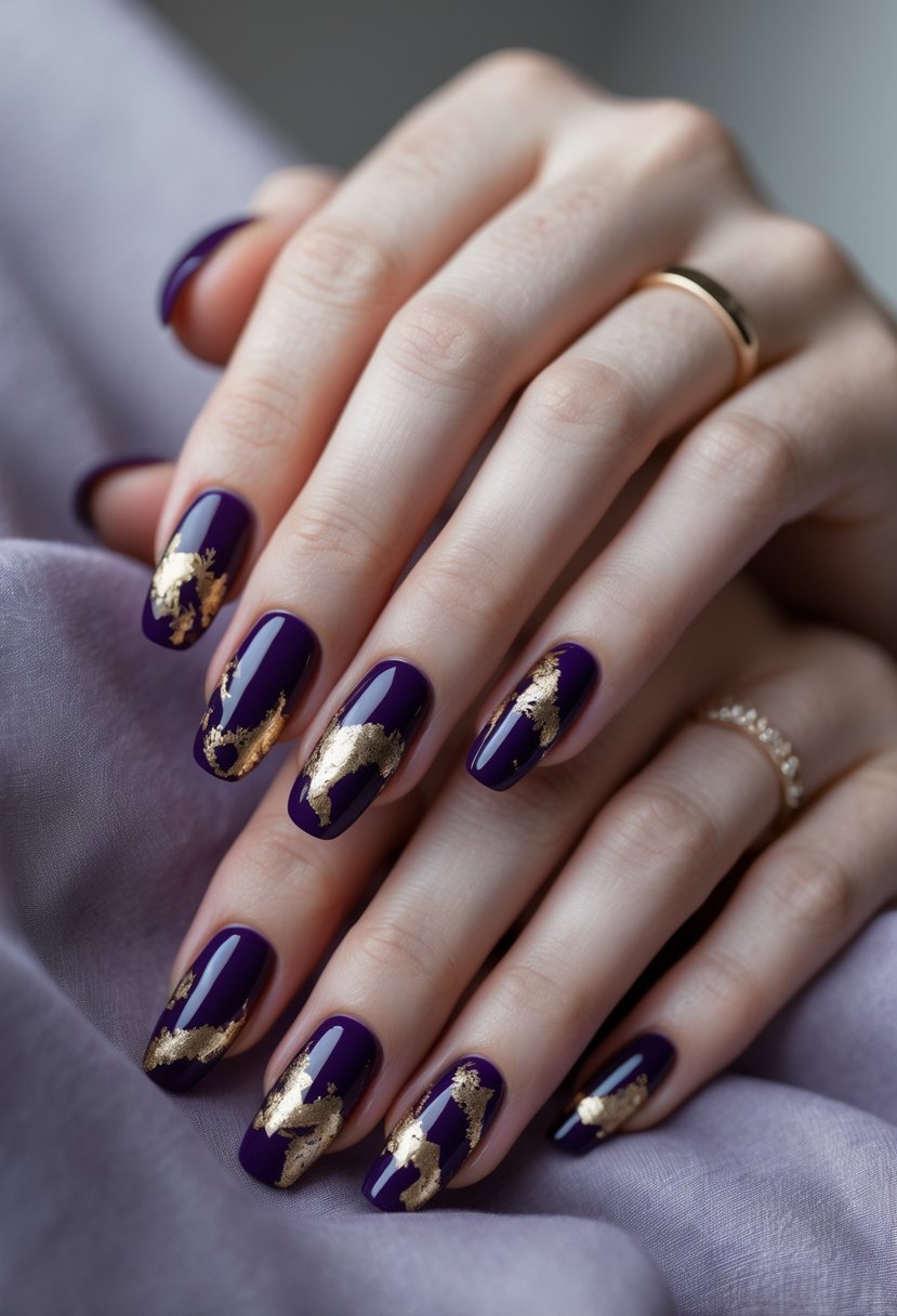 Close-up of hands with dark purple nails and gold foil accents.